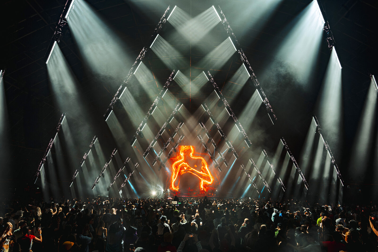 Faithless at Creamfields 2026: triangles of white beams framing a neon figure