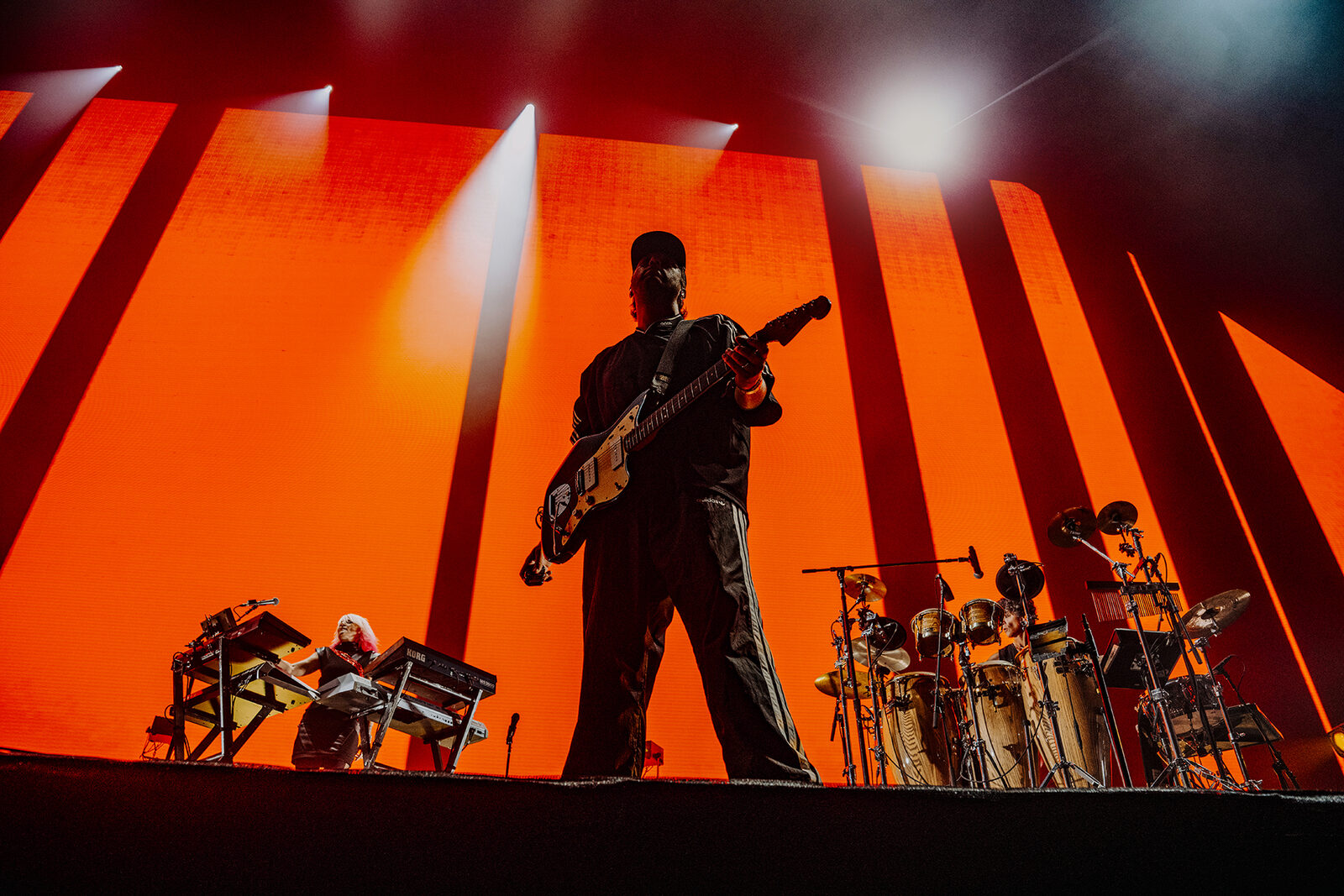 Bassist against orange light columns, Faithless at Creamfields 2026