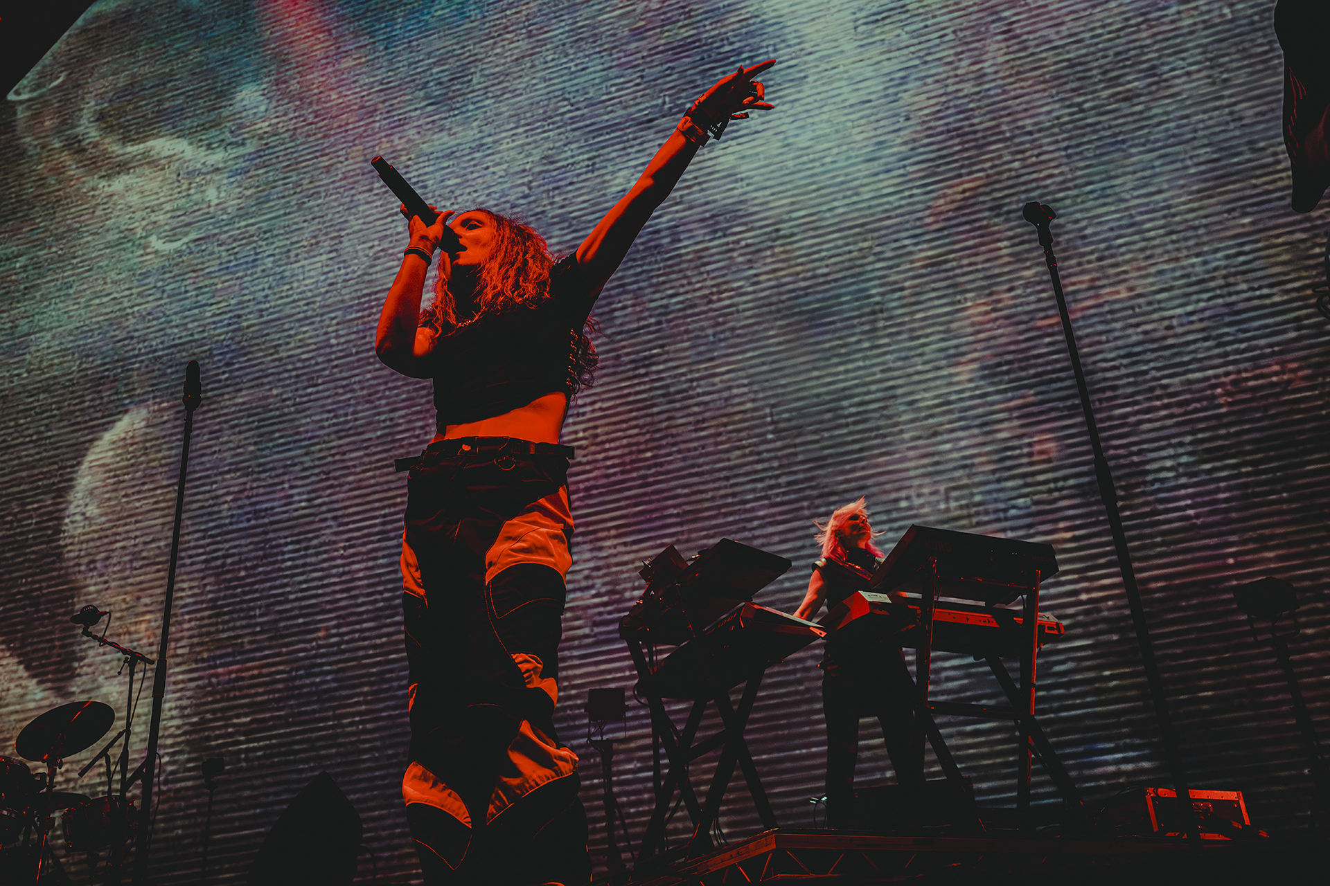 Singer with arms raised against a textured backdrop, Faithless at Creamfields 2026