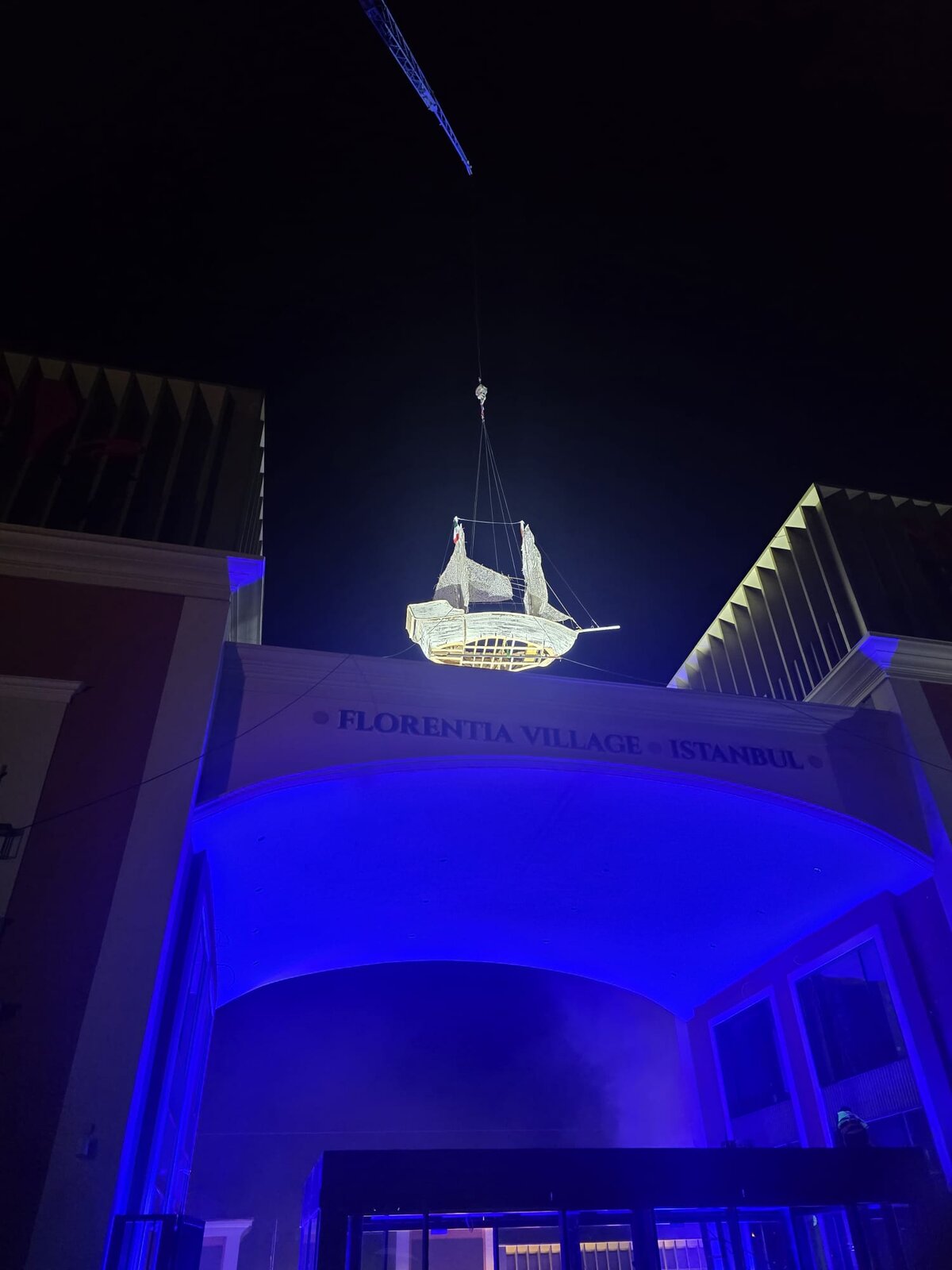 The galleon suspended over the entrance in blue light